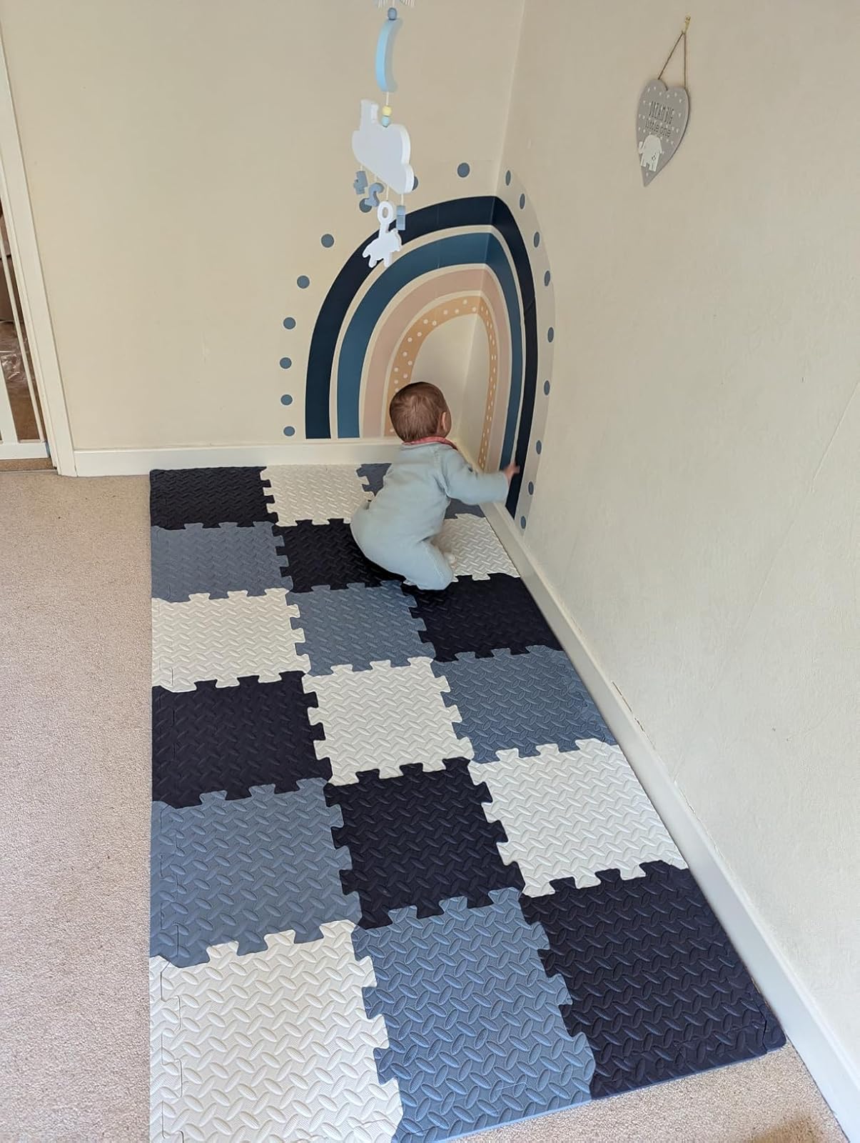 infant safely crawling on playmat tiles